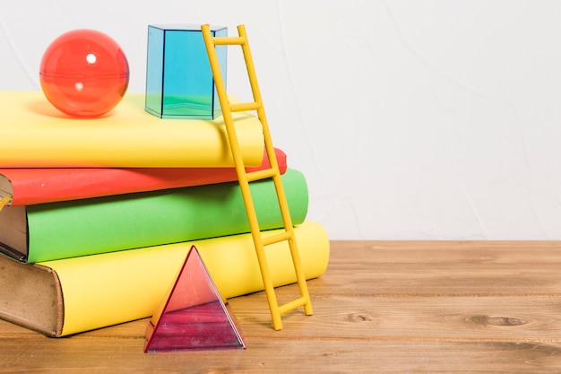 Papierladder op stapel kleurrijke boeken en speelgoed