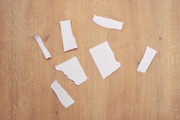 Papierresten. Gescheurde papieren, gescheurde pagina op een houten tafel.