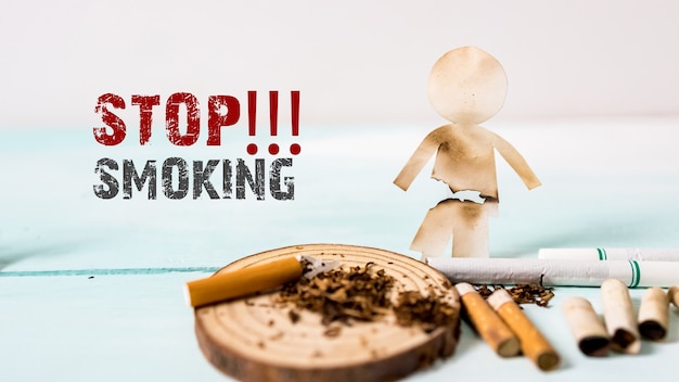 Papiersnijding van familie vernietigd door sigaretten. Drugs die het familieconcept vernietigen. Stoppen met roken voor het leven op World no Tobacco day concept. Werelddag zonder tabak.