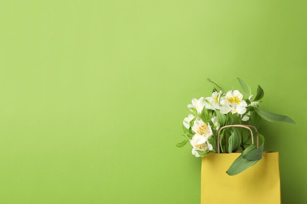 Papierzak voor winkelen met bloemen op een groene achtergrond