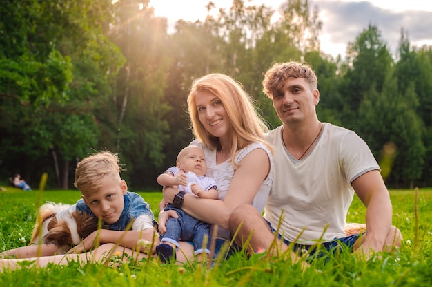 Pappa en mamma met hun twee kinderen die buiten buiten de stad rusten en spelen