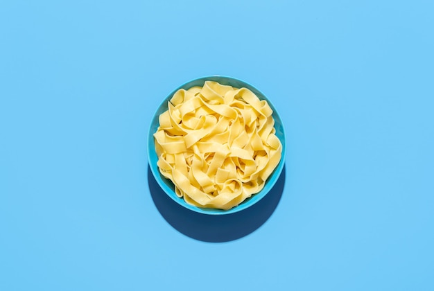 Pappardelle pasta bowl isolated on a blue background