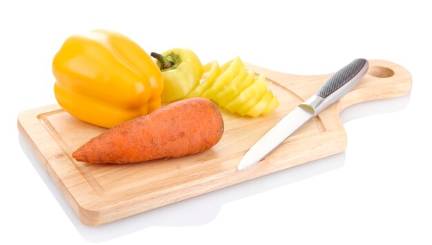 Морковь с паприкой и нож на деревянной разделочной доске, изолированной на белом