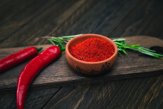 Paprika chilipepers en rozemarijn op een houten bord