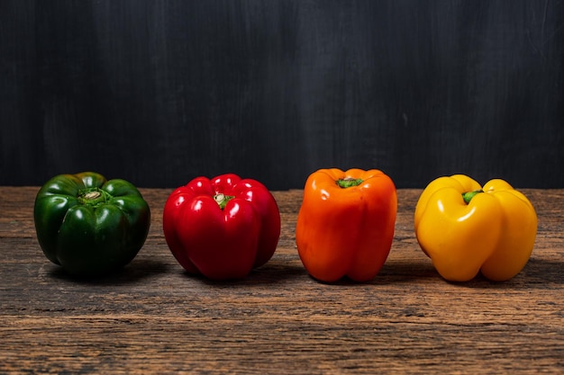 Paprika Pepper red yellow orange and green on wooden table Bell pepper isolated