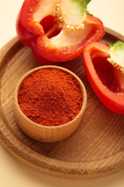 Paprika powder with fresh red pepper on beige background Vertical photo