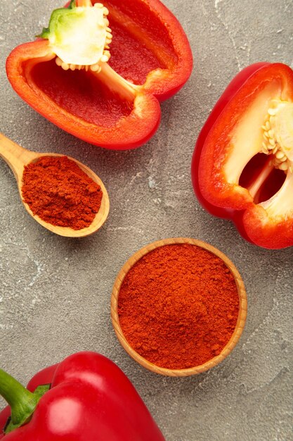 Foto polvere di paprika con pepe rosso fresco su sfondo grigio foto verticale