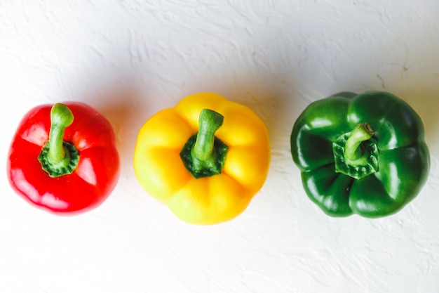 Foto paprika's op witte achtergrond, rood, groen en geel. dieet concept.
