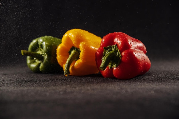 Paprika's op zwarte achtergrond paprika met druppels