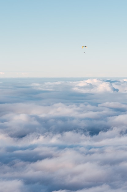 Parachutist die boven de wolken vliegt