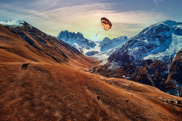 낙하산병은 그림처럼 아름다운 산 계곡 위로 날아갑니다. 무중력과 자유로움으로 하늘을 나는 기분