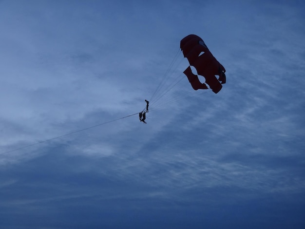 Foto parachutist in de lucht bij zonsondergang kite surfing