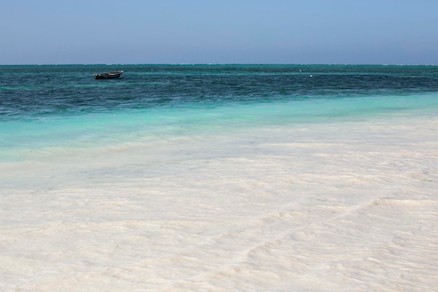 Paradise beach with turquoise water and sail boat in the sea, Nungwi village, Zanzibar, Tanzania