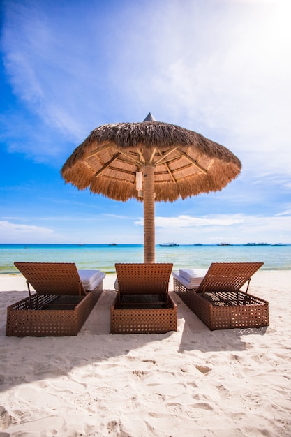 Paradise view of nice tropical empty sandy plage with umbrella and beach chair