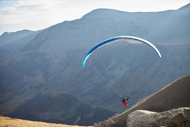 Paraglide silhouette over mountain peaks high quality photo