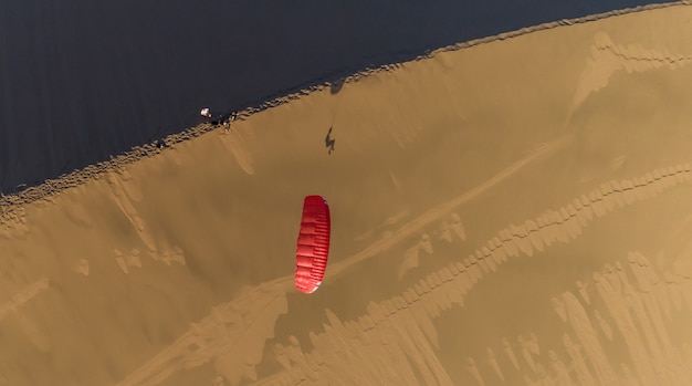 砂丘上面図を背景にしたパラグライダー