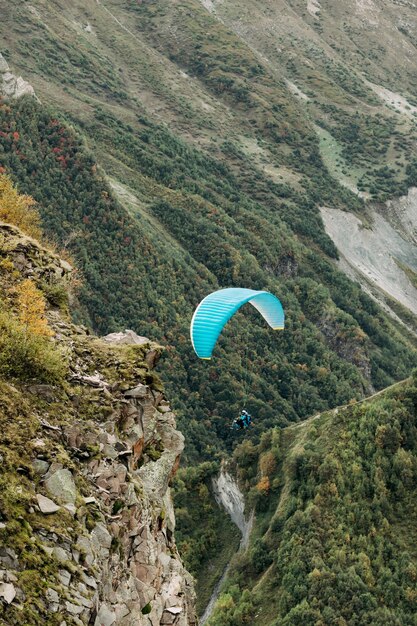 Foto il parapendio vola sopra la montagna in una giornata di sole