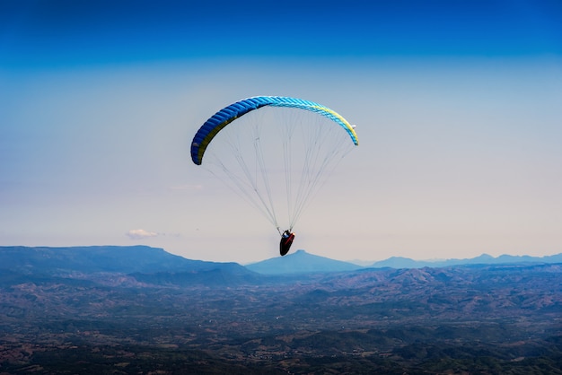 Photo paraglider flying over mountains in the morning on summer day at north of thailand.