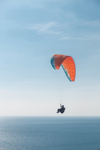 Paraglider flying over the sea