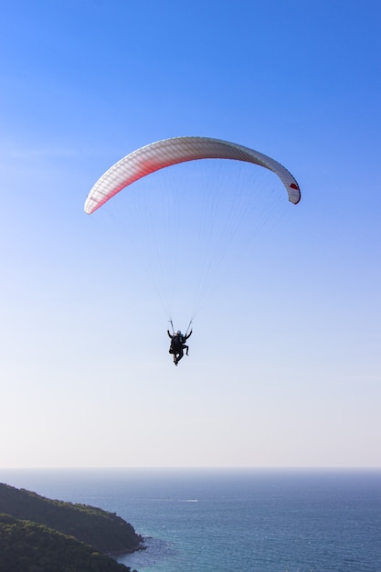 Foto parapendio che vola sopra il mare.