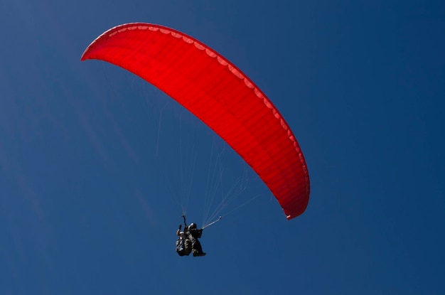 Paraglider taking off in deep blue sky