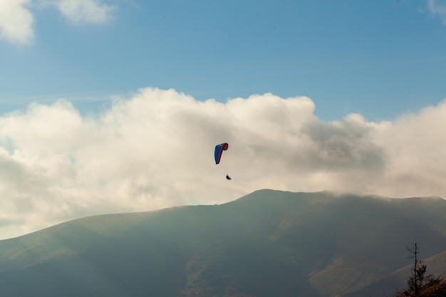 Paraglider vliegen over wolken in zomerdag