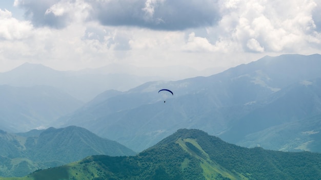 Paraglider vliegt in de bergen van de kaukasus