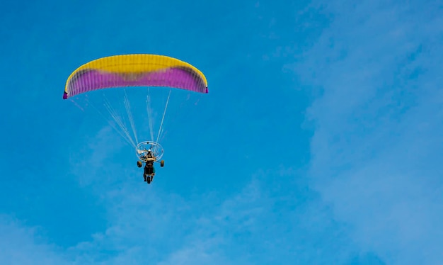 Il parapendio con un motore vola nel cielo blu