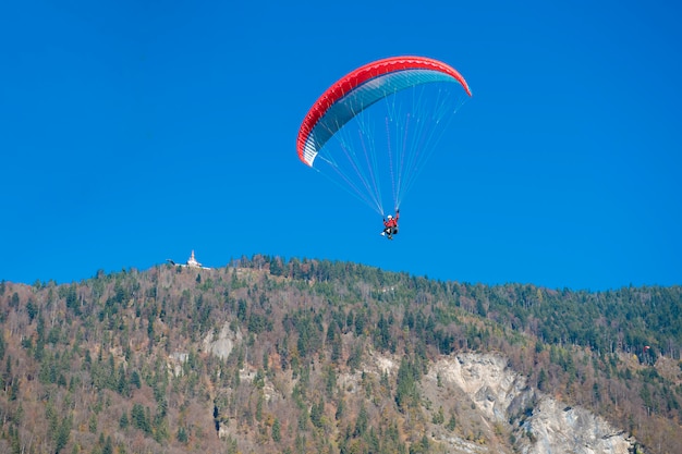 Paragliders die met paramotors met mooie bergmening vliegen tegen blauwe hemel