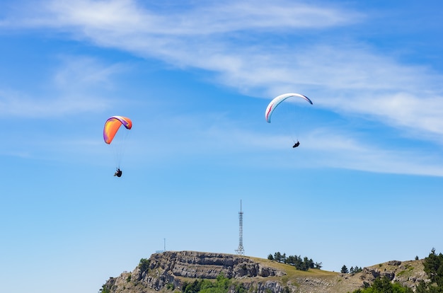 Paragliders soaring above the mountain top