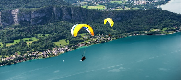 Paragliders with parapente jumping  near of lake of Annecy in French Alps, in France.