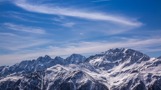 Paragliding over Alps with mountain cliffs covered with snow in Karnten Austria