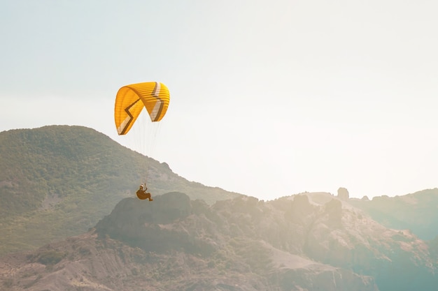 Parapendio nel cielo sopra il mare e le montagne