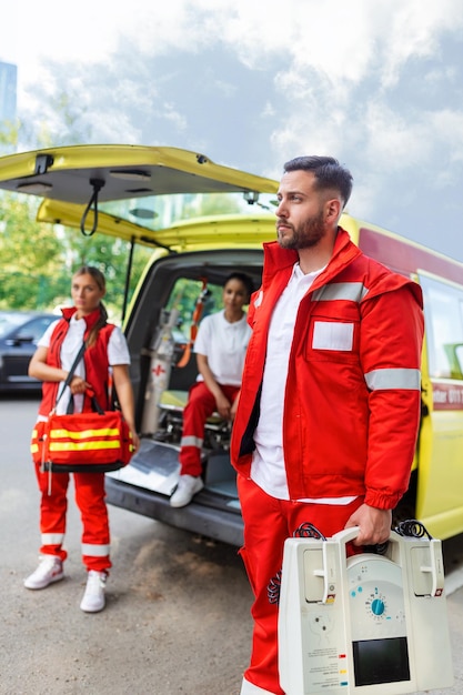 Paramedic nurse and emergency doctor at ambulance with kit a paramedic standing at the rear of an ambulance by the open doors