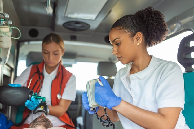 Paramedic using defibrillator AED in conducting a basic cardiopulmonary resuscitation Emergency Care Assistant Putting Silicone Manual Resuscitators in an Ambulance