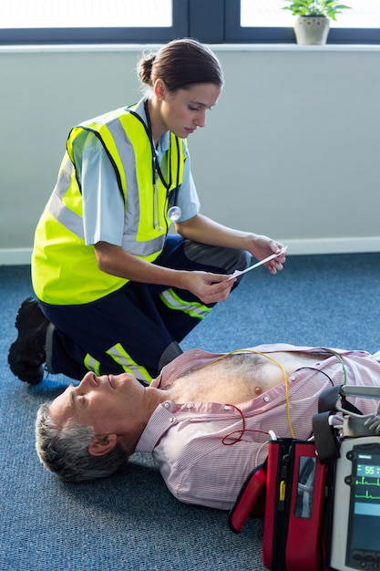 Foto paramedico che utilizza un defibrillatore esterno durante la rianimazione cardiopolmonare