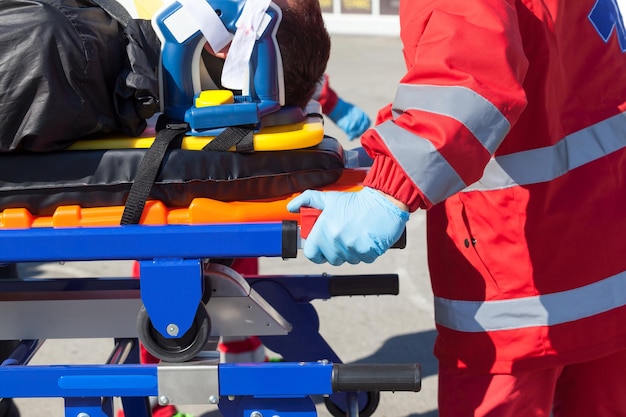 Photo paramedic with patient on stretcher at street