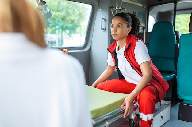 Paramedici die ambulancebrancard uit auto halen paramedici rollen de ambulancebrancard