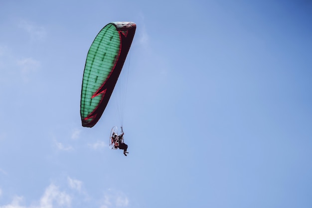 Paramotor flying on blue sky