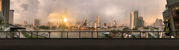 Paranamic view of Bangkok urban cityscape skyline night scene with empty loft cement floor on front