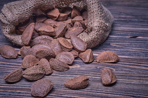 Photo paranuts vegetarian food in a bag on old wooden background