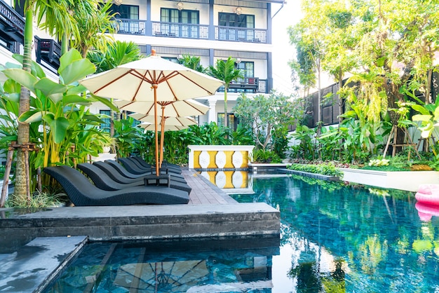 paraplu en bed zwembadstoel rond zwembad - concept vakantie en reizen vakantie