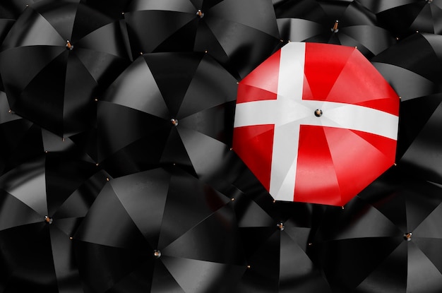 Paraplu met Deense vlag onder zwarte paraplu's 3D-rendering