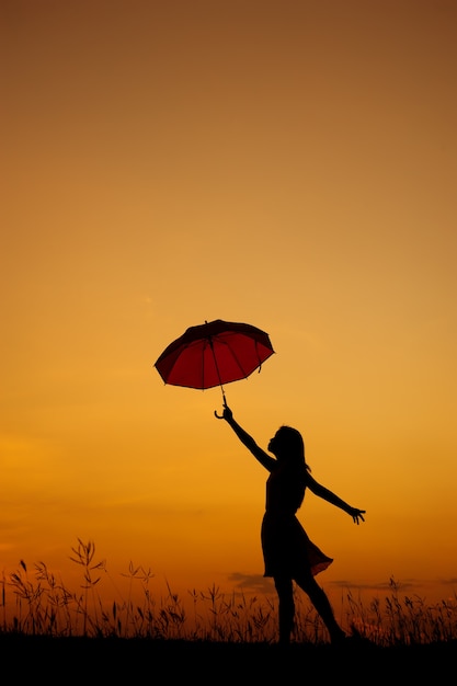 Paraplu Vrouw Staande en zonsondergang silhouet