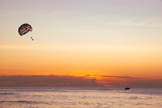 Parasailing on the sea against the backdrop of the setting sun