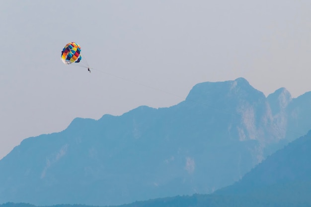 Parasailing over sea on a background of mountains