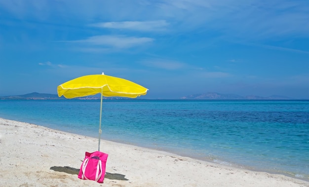 Parasol and bag on a desert beach