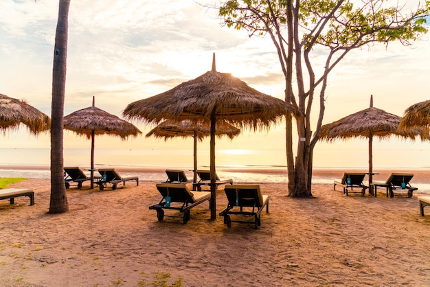 Parasol en stoel rond zwembad in resorthotel voor vakantiereizen en vakantie dichtbij zee oceaanstrand bij zonsondergang of zonsopgang