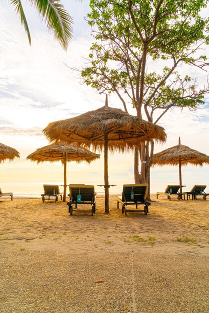 Parasol en stoel rond zwembad in resorthotel voor vakantiereizen en vakantie nabij zee oceaan strand bij zonsondergang of zonsopgang