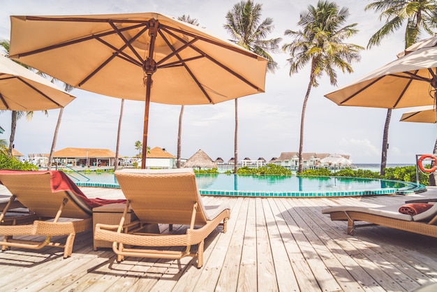 Parasol en stoel rond zwembad in resorthotel